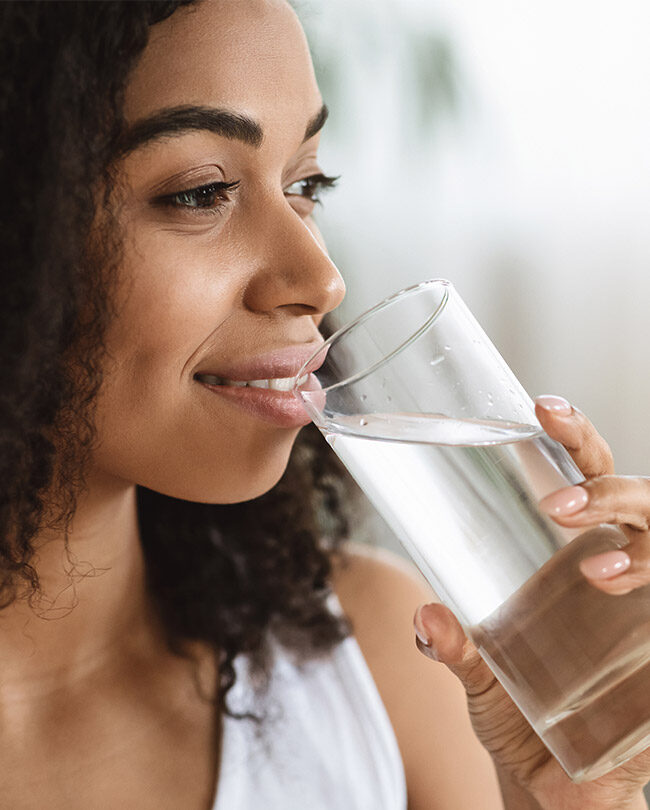 Black woman drinking liquid from glass